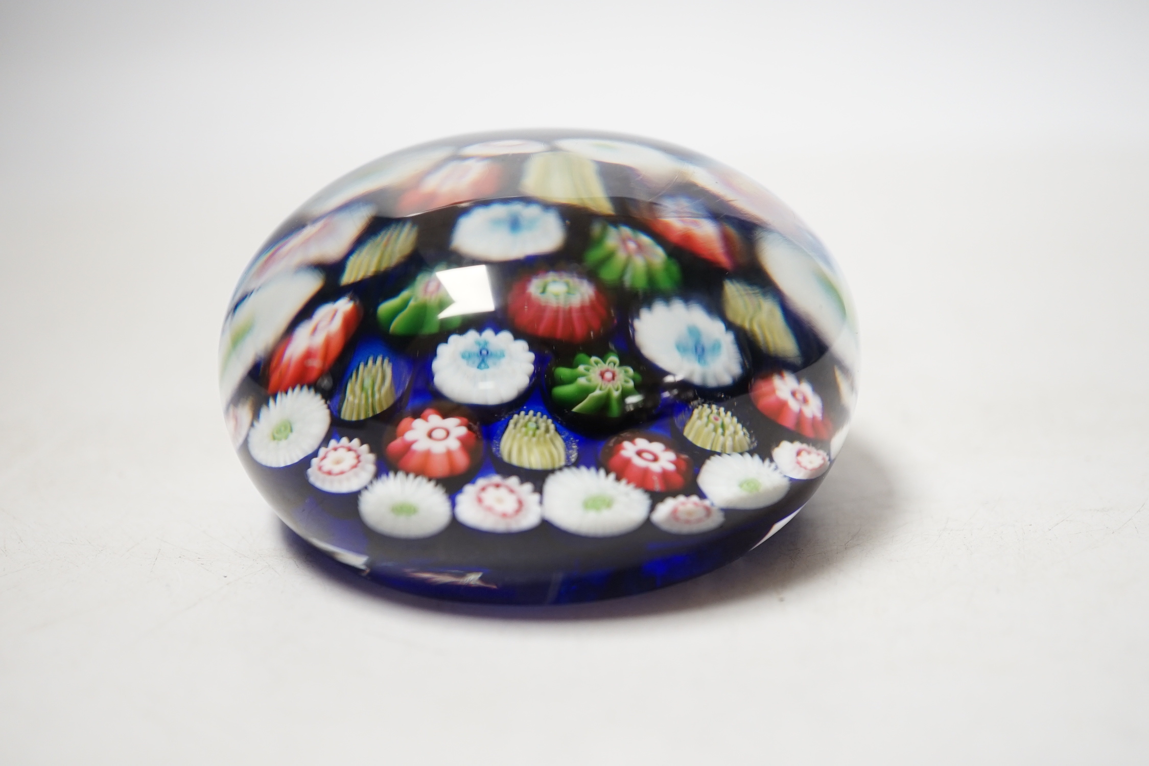 A Clichy translucent blue ground millefiori glass paperweight, 7cm in diameter